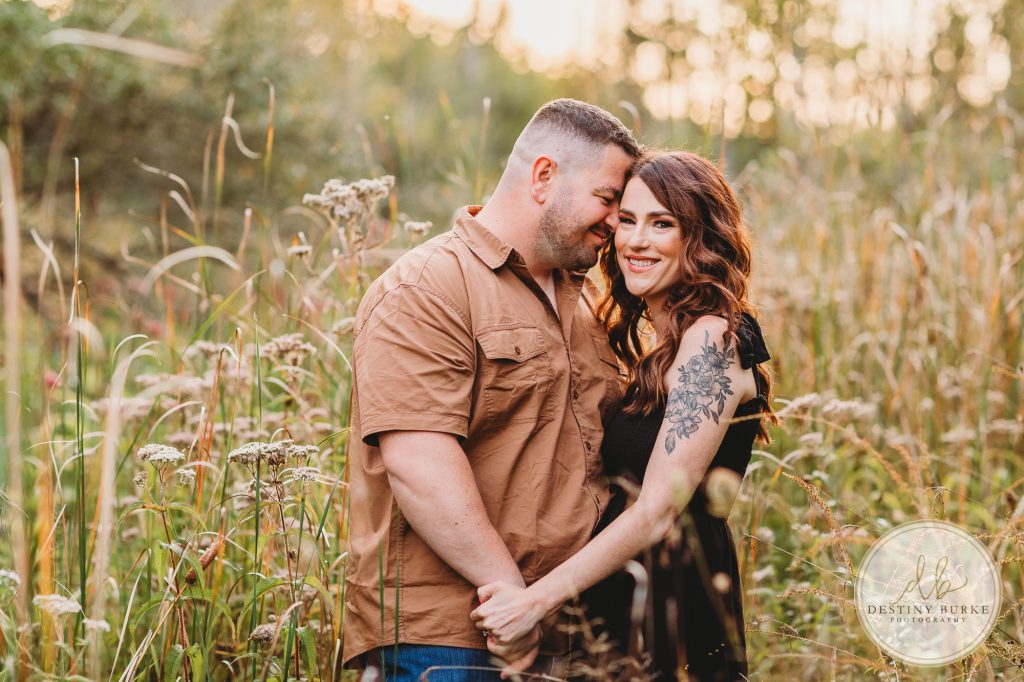 Family posing for family portrait photography session in Chili, NY at Black Creek Park near Rochester, NY
