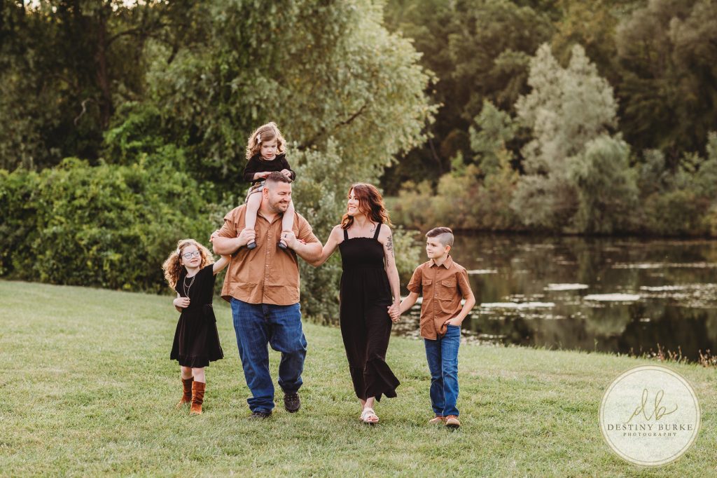 Family posing for family portrait photography session in Chili, NY at Black Creek Park near Rochester, NY