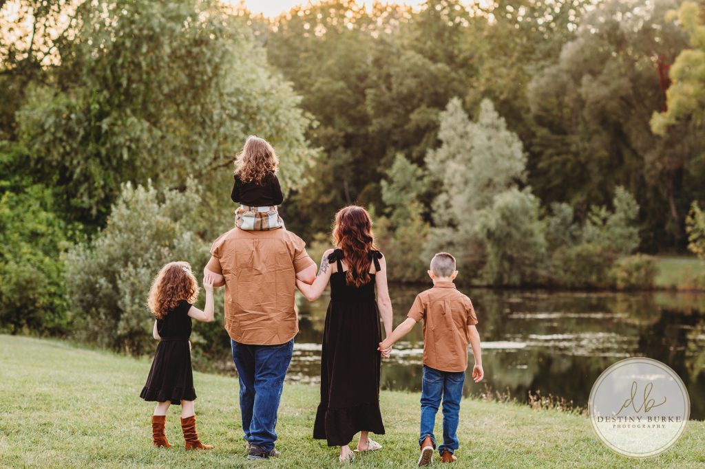 Family posing for family portrait photography session in Chili, NY at Black Creek Park near Rochester, NY