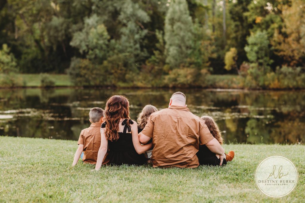 Family posing for family portrait photography session in Chili, NY at Black Creek Park near Rochester, NY