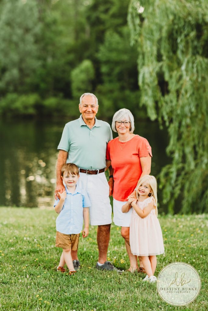 Extended family portrait of the Landry Family taken during golden hour in Rochester, NY. Captured by Destiny Burke Photography, featuring multiple generations with natural posing, warm light, and candid emotion.