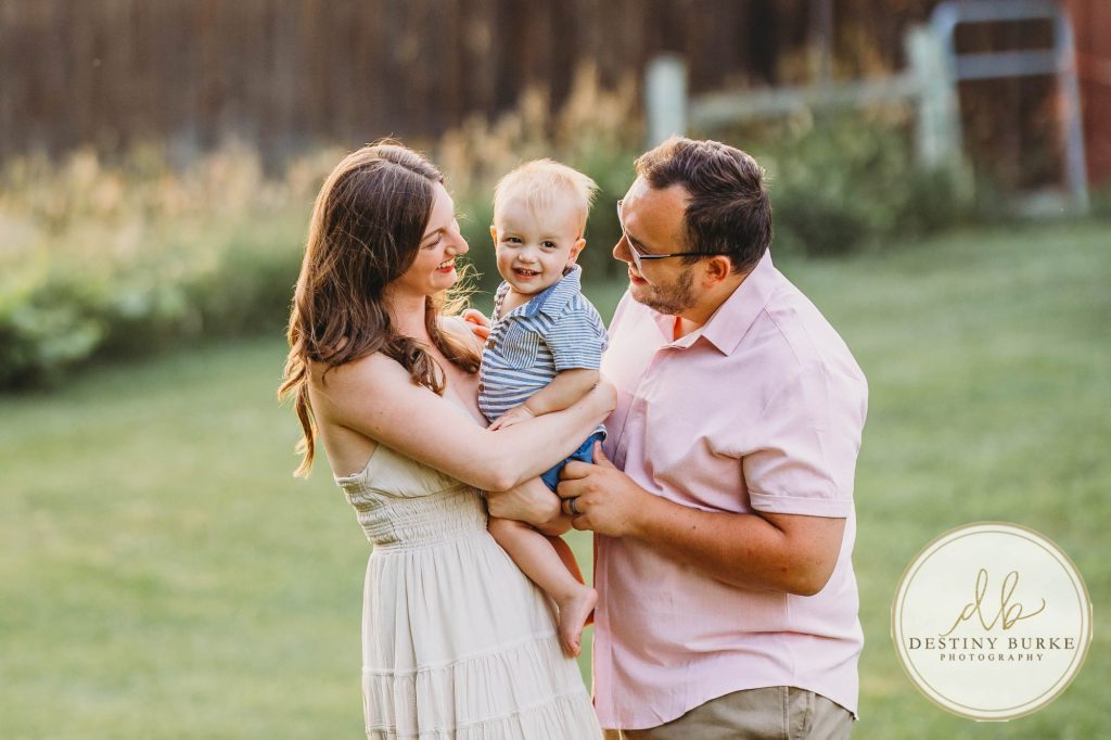 Golden hour extended family photo of the Carson/Ingersoll family in Caledonia, NY, featuring parents, grandparents, and their smiling young child. Captured by Destiny Burke Photography with warm light, candid emotion, and timeless connection.