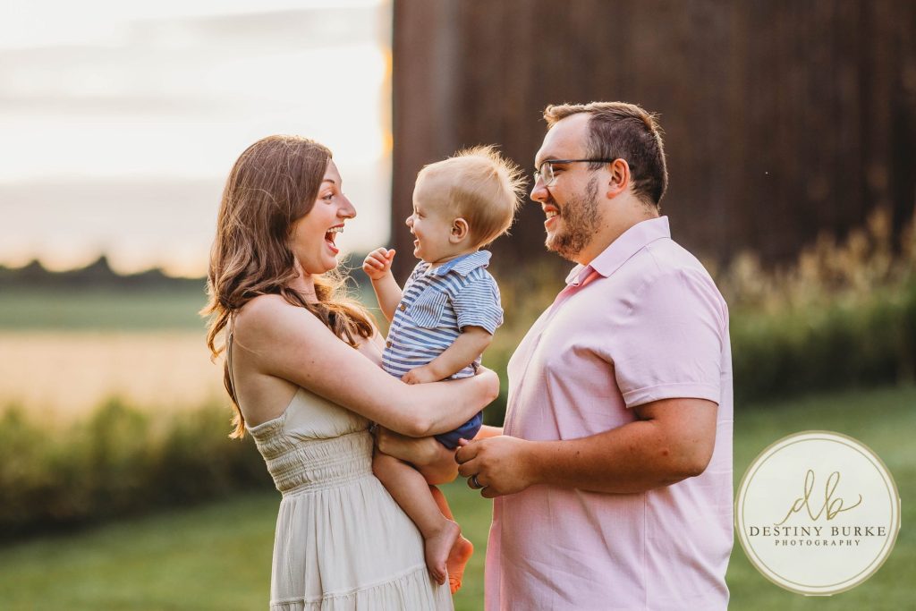 Golden hour extended family photo of the Carson/Ingersoll family in Caledonia, NY, featuring parents, grandparents, and their smiling young child. Captured by Destiny Burke Photography with warm light, candid emotion, and timeless connection.