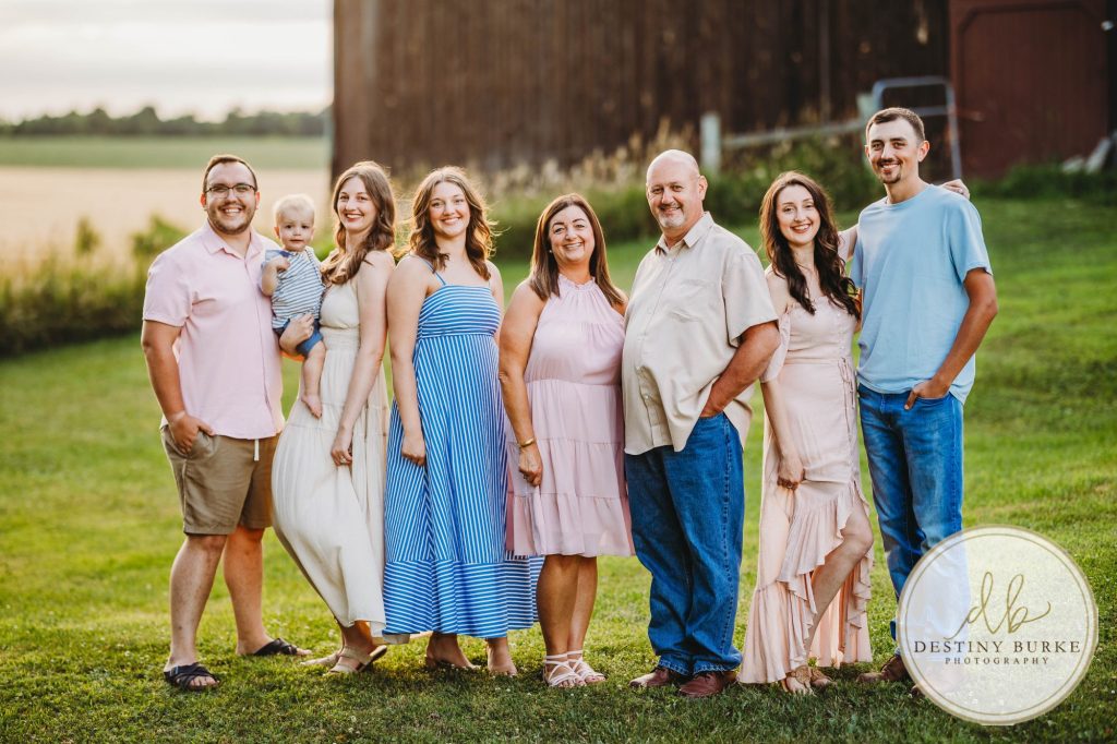 Golden hour extended family photo of the Carson/Ingersoll family in Caledonia, NY, featuring parents, grandparents, and their smiling young child. Captured by Destiny Burke Photography with warm light, candid emotion, and timeless connection.