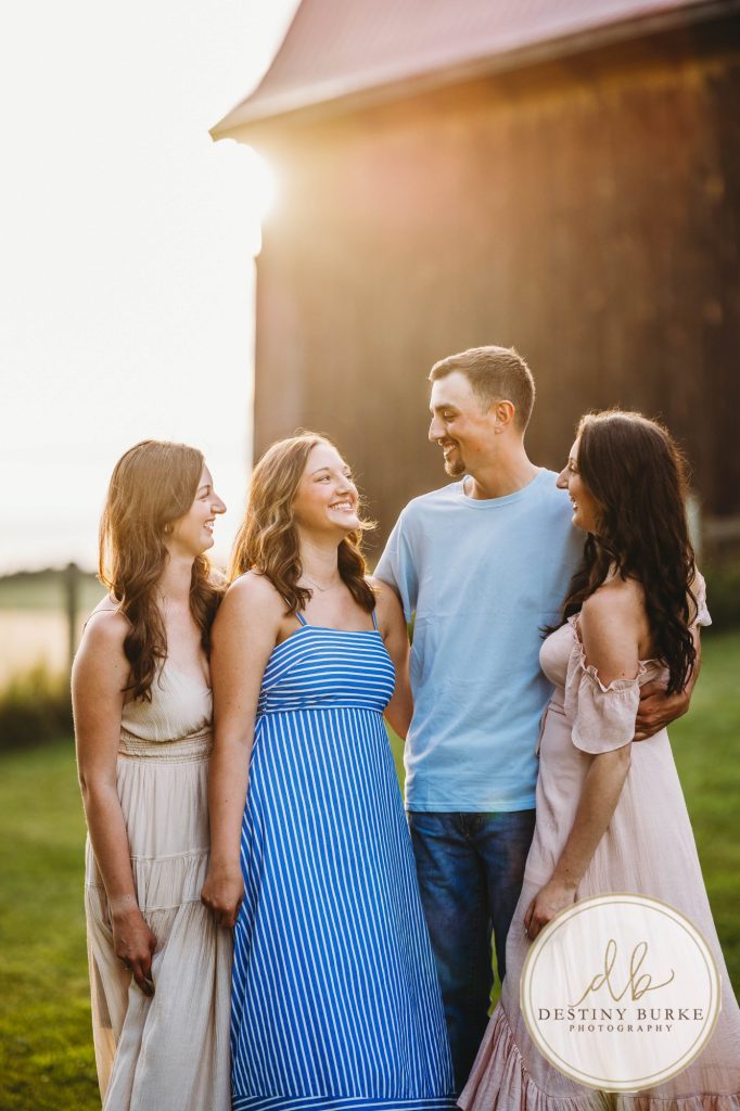 Golden hour extended family photo of the Carson/Ingersoll family in Caledonia, NY, featuring parents, grandparents, and their smiling young child. Captured by Destiny Burke Photography with warm light, candid emotion, and timeless connection.