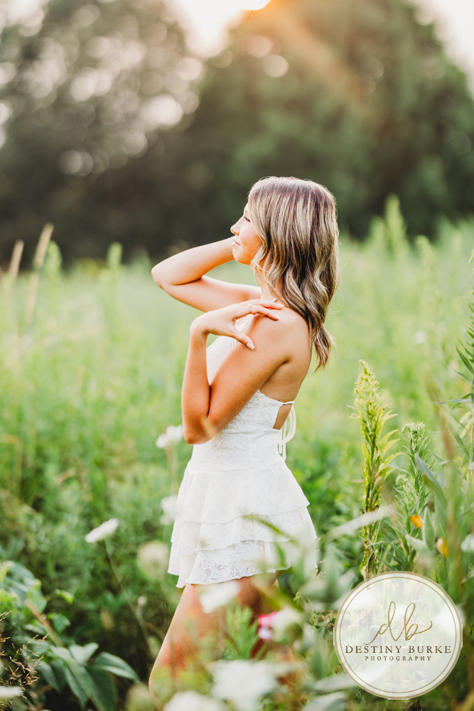 best Senior Portrait Photographer near Rochester, NY at Tinker Park with wildflowers at sunset golden hour