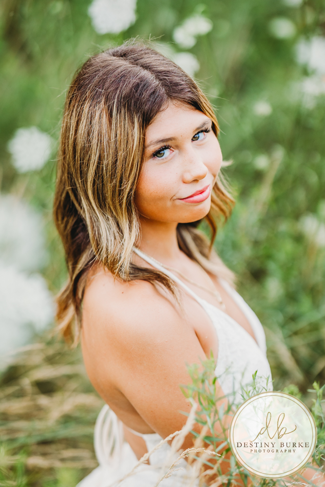 best Senior Portrait Photographer near Rochester, NY at Tinker Park with wildflowers at sunset golden hour