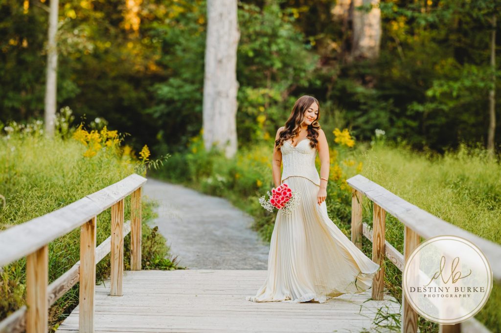 best Senior Portrait Photographer near Rochester, NY at Tinker Park with wildflowers at sunset golden hour