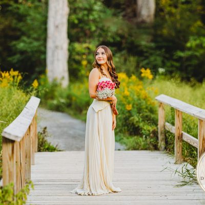 best Senior Portrait Photographer near Rochester, NY at Tinker Park with wildflowers at sunset golden hour