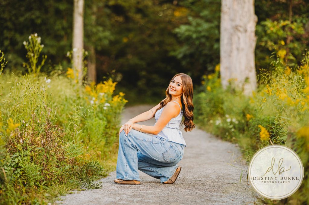 best Senior Portrait Photographer near Rochester, NY at Tinker Park with wildflowers at sunset golden hour