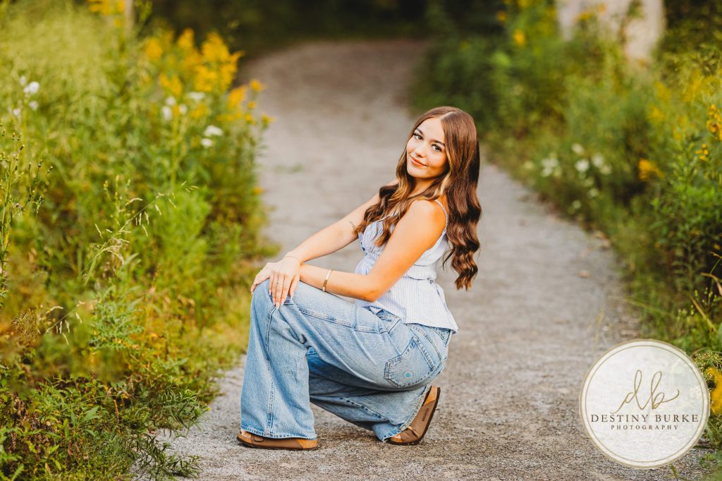 best Senior Portrait Photographer near Rochester, NY at Tinker Park with wildflowers at sunset golden hour