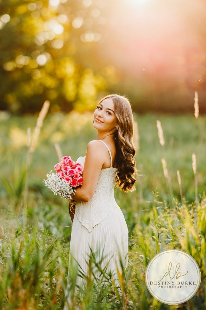 best Senior Portrait Photographer near Rochester, NY at Tinker Park with wildflowers at sunset golden hour