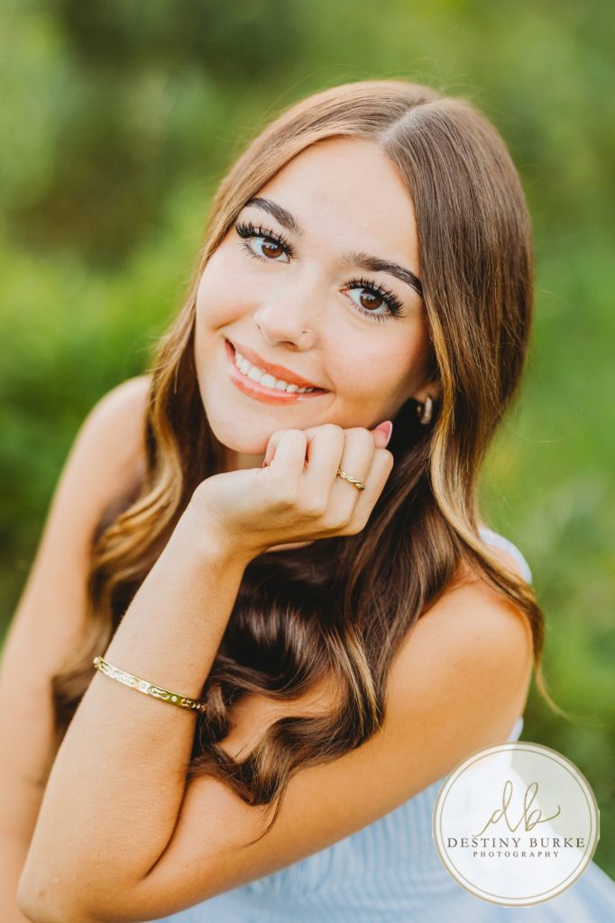 best Senior Portrait Photographer near Rochester, NY at Tinker Park with wildflowers at sunset golden hour