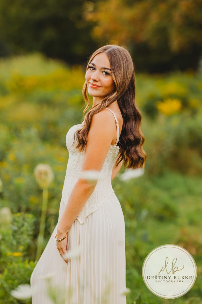 best Senior Portrait Photographer near Rochester, NY at Tinker Park with wildflowers at sunset golden hour