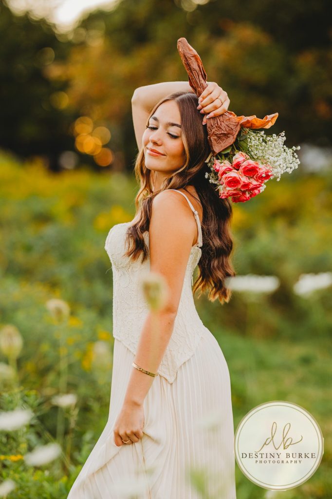 best Senior Portrait Photographer near Rochester, NY at Tinker Park with wildflowers at sunset golden hour